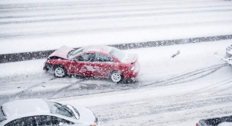 Coches en una carretera cubierta de nieve durante una tormenta invernal.